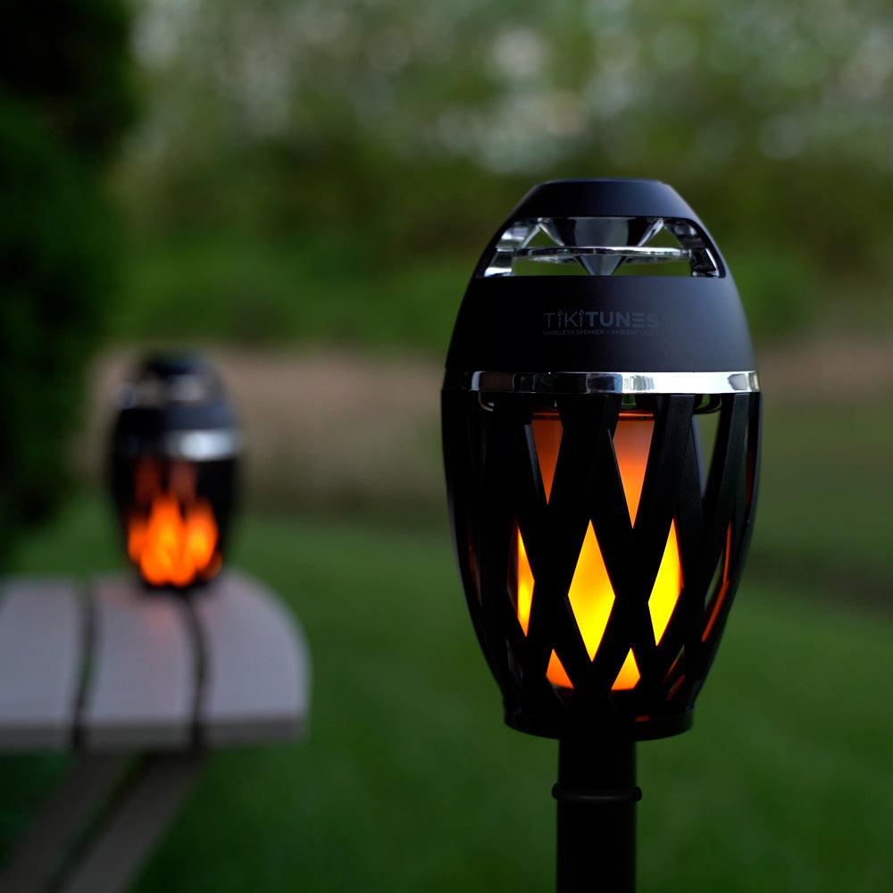 Tiki torches with flame effect on a blurred outdoor background