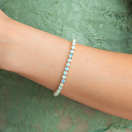 Gold bracelet with opal stones on a white background