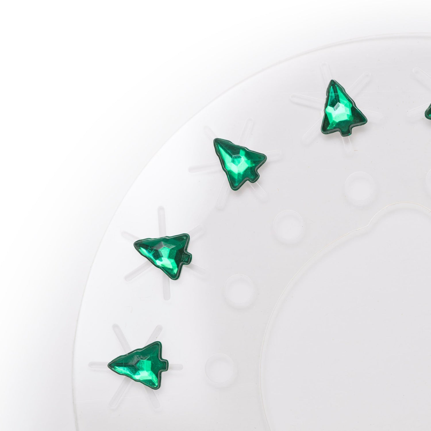 Green tree-shaped rhinestones on a white background