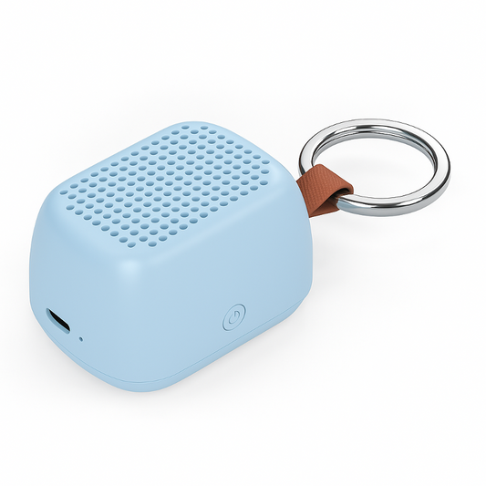 A light blue portable Bluetooth speaker with a brown leather strap and a silver metal key ring, shown on a clean white background.
