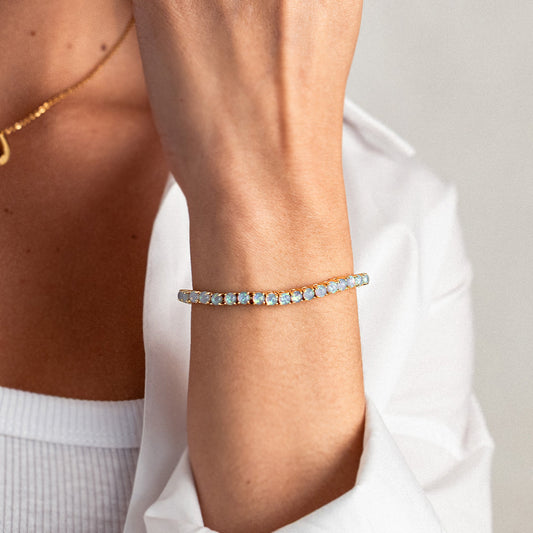 Gold bracelet with opal stones on a white background