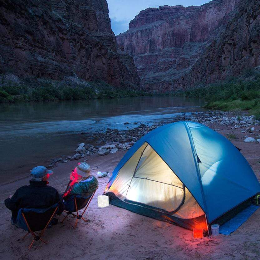 This camp side is using the twilight with red light to keep mosquitos away. This couple have our solar lanterns ready for the sunset.