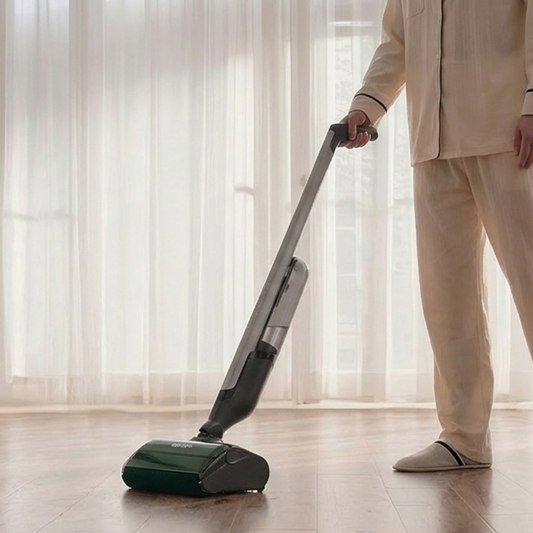 Person using a vacuum cleaner on a wooden floor in a kitchen.