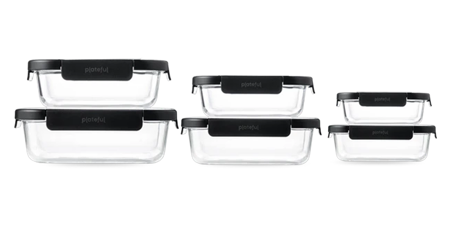 Set of glass food storage containers with black lids on a white background