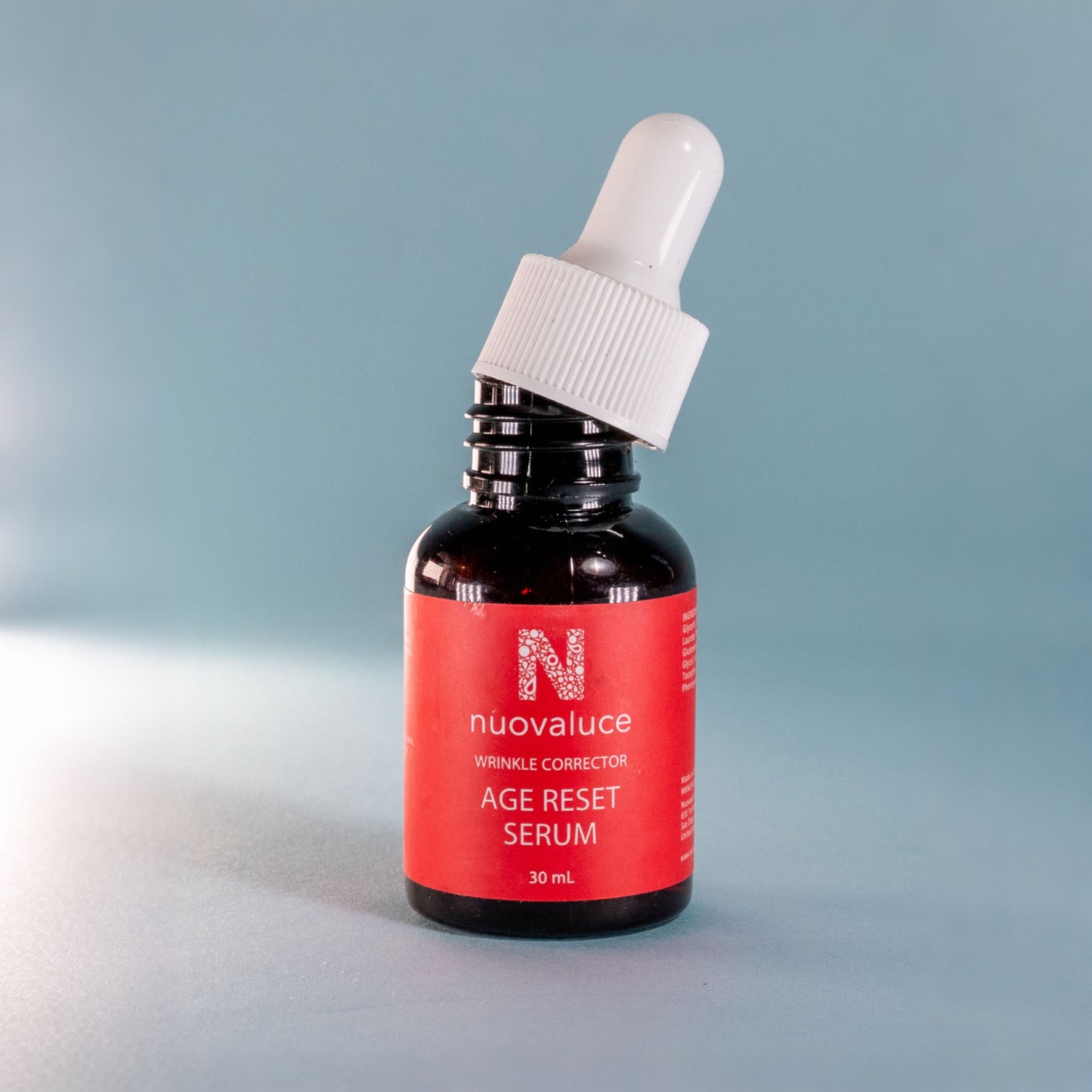 Bottle of nuvaluace age reset serum with dropper on a gradient background
