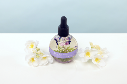 Bottle of essential oil with floral design on a light background