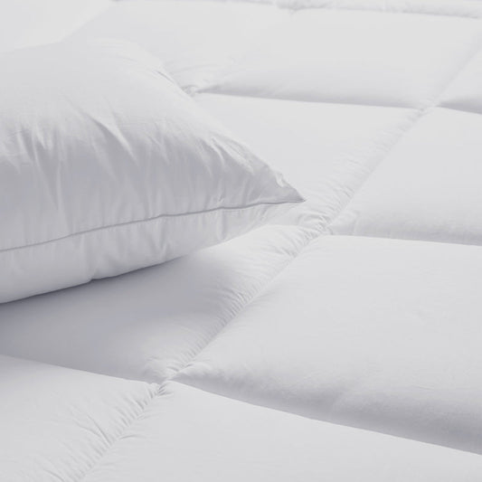 White comforter on a bed in a modern bedroom setting