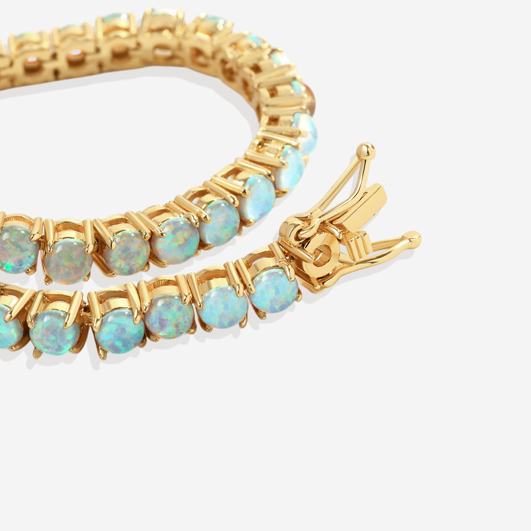 Gold bracelet with opal stones on a white background