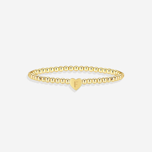 Gold beaded bracelet with a heart-shaped clasp on a white background