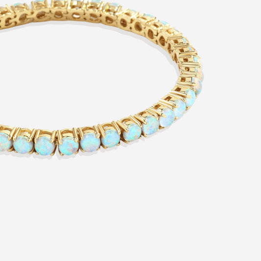 Gold bracelet with opal stones on a white background