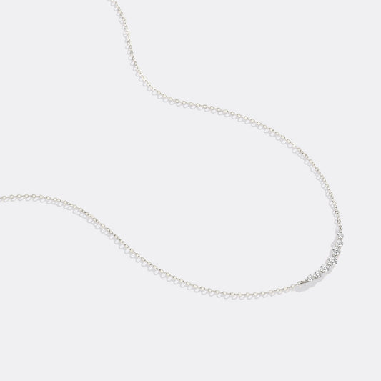 Gold necklace with small diamonds on a white background