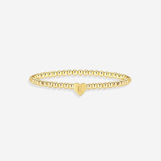 Gold beaded bracelet with a heart-shaped clasp on a white background