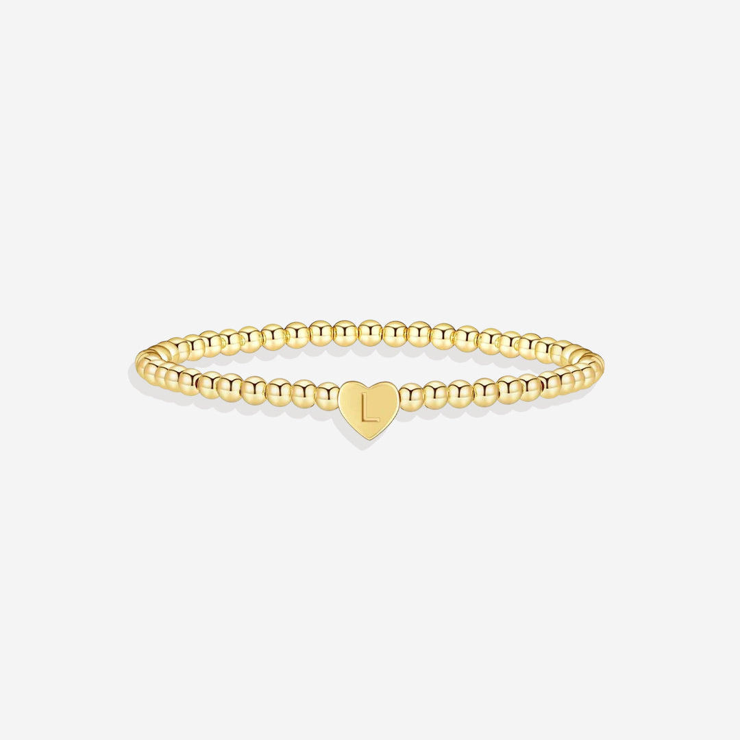 Gold bracelet with a heart-shaped charm on a white background