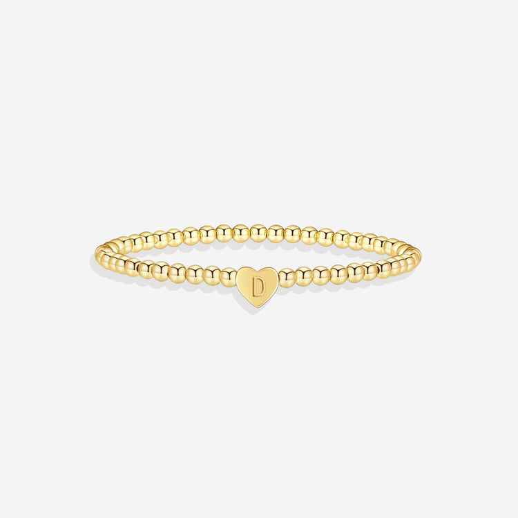 Gold bracelet with a heart-shaped charm on a white background