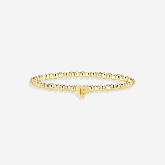 Gold beaded bracelet with a heart-shaped clasp on a white background
