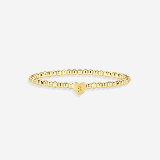 Gold beaded bracelet with a heart-shaped clasp on a white background