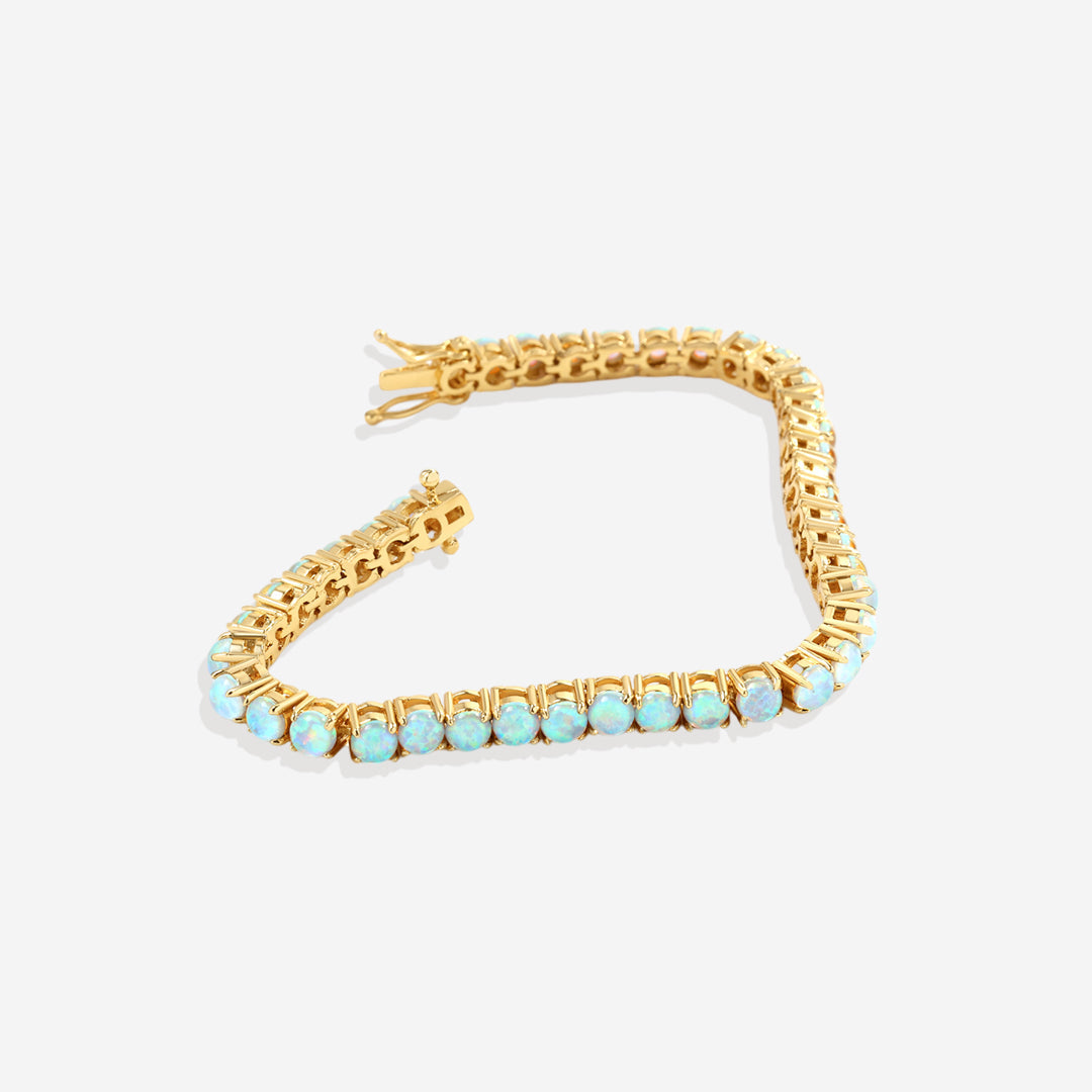 Gold bracelet with turquoise stones on a white background
