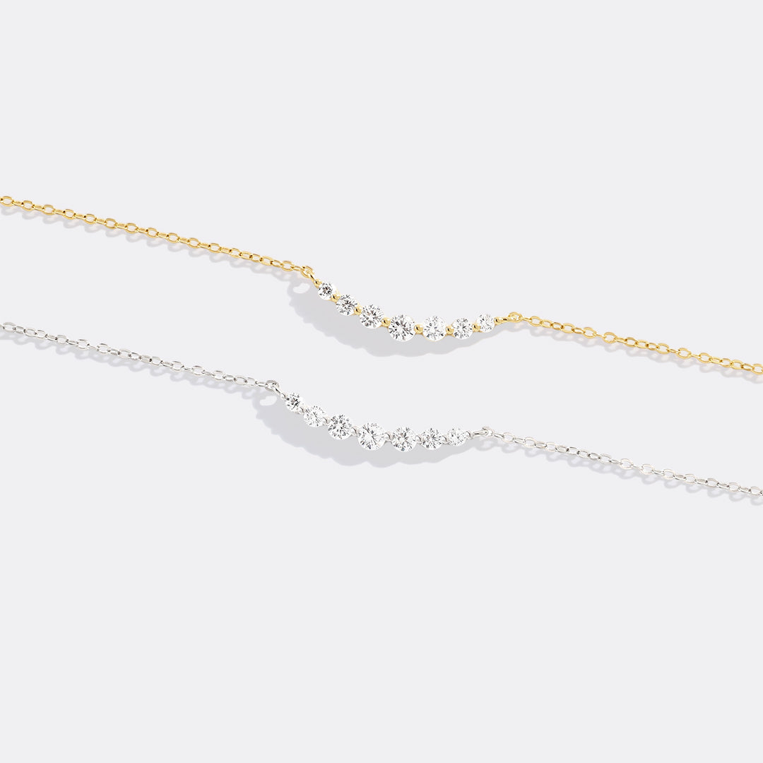 Two gold necklaces on a white background