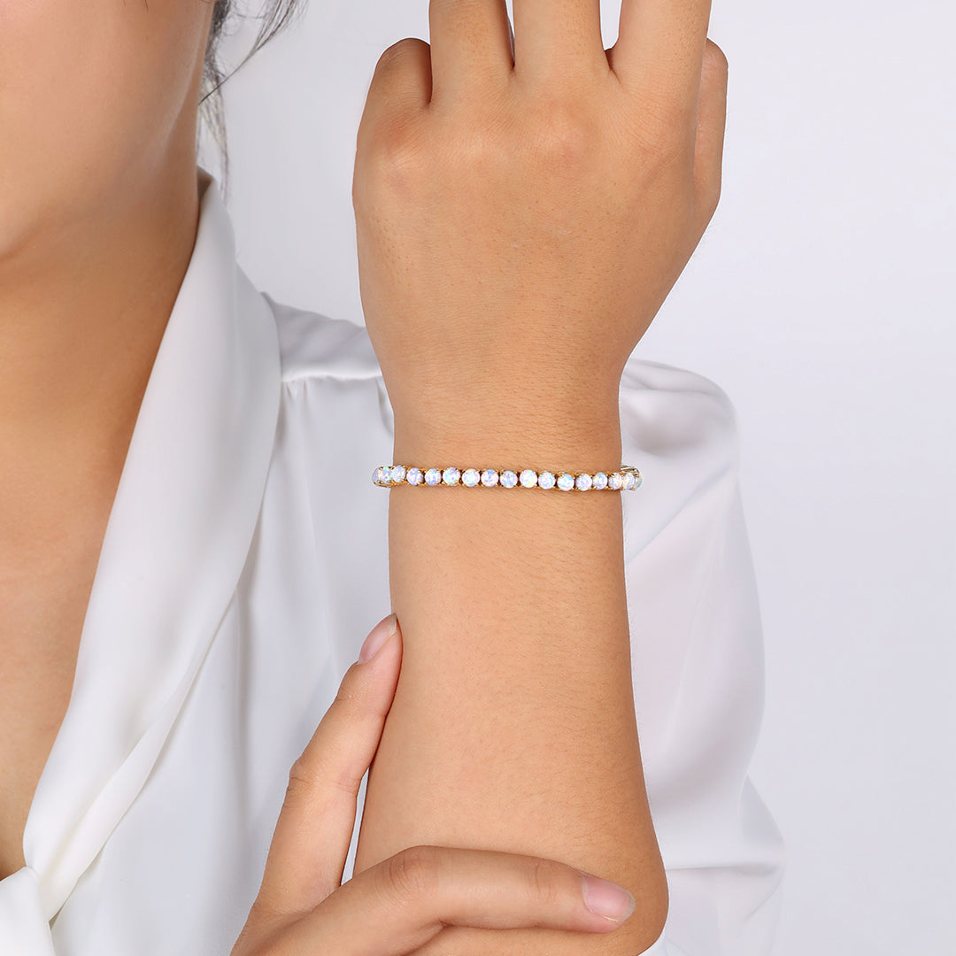 Close-up of a hand wearing a pearl bracelet against a white background
