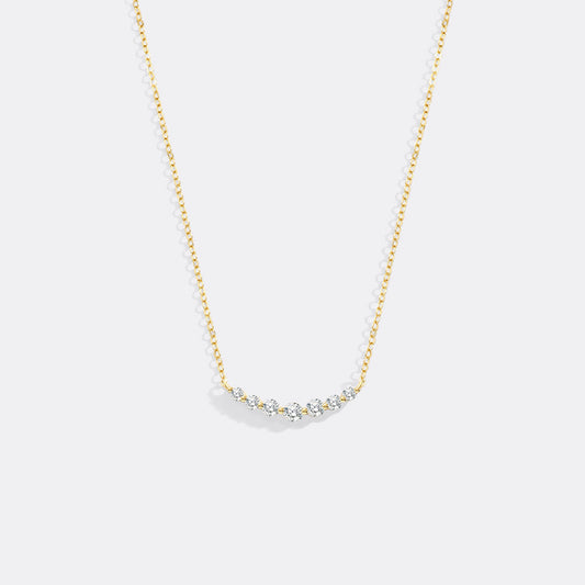 Gold necklace with small diamonds on a white background