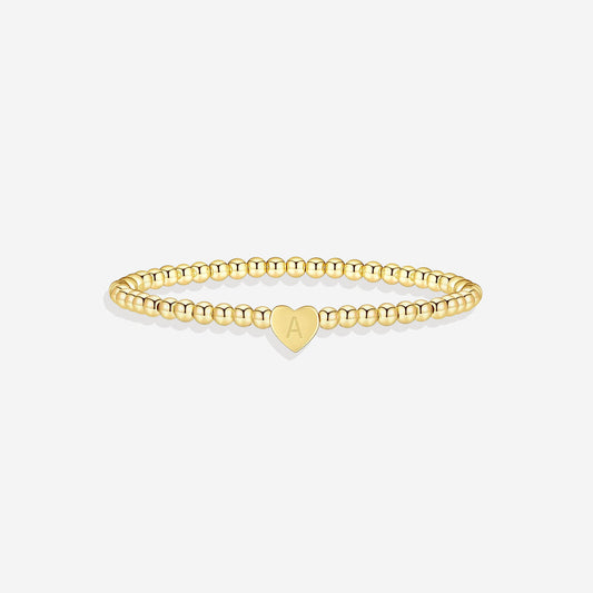 Gold beaded bracelet with a heart-shaped clasp on a white background