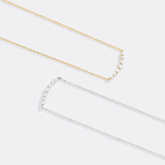 Gold necklace with small diamonds on a white background