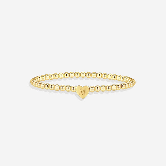 Gold beaded bracelet with a heart-shaped clasp on a white background