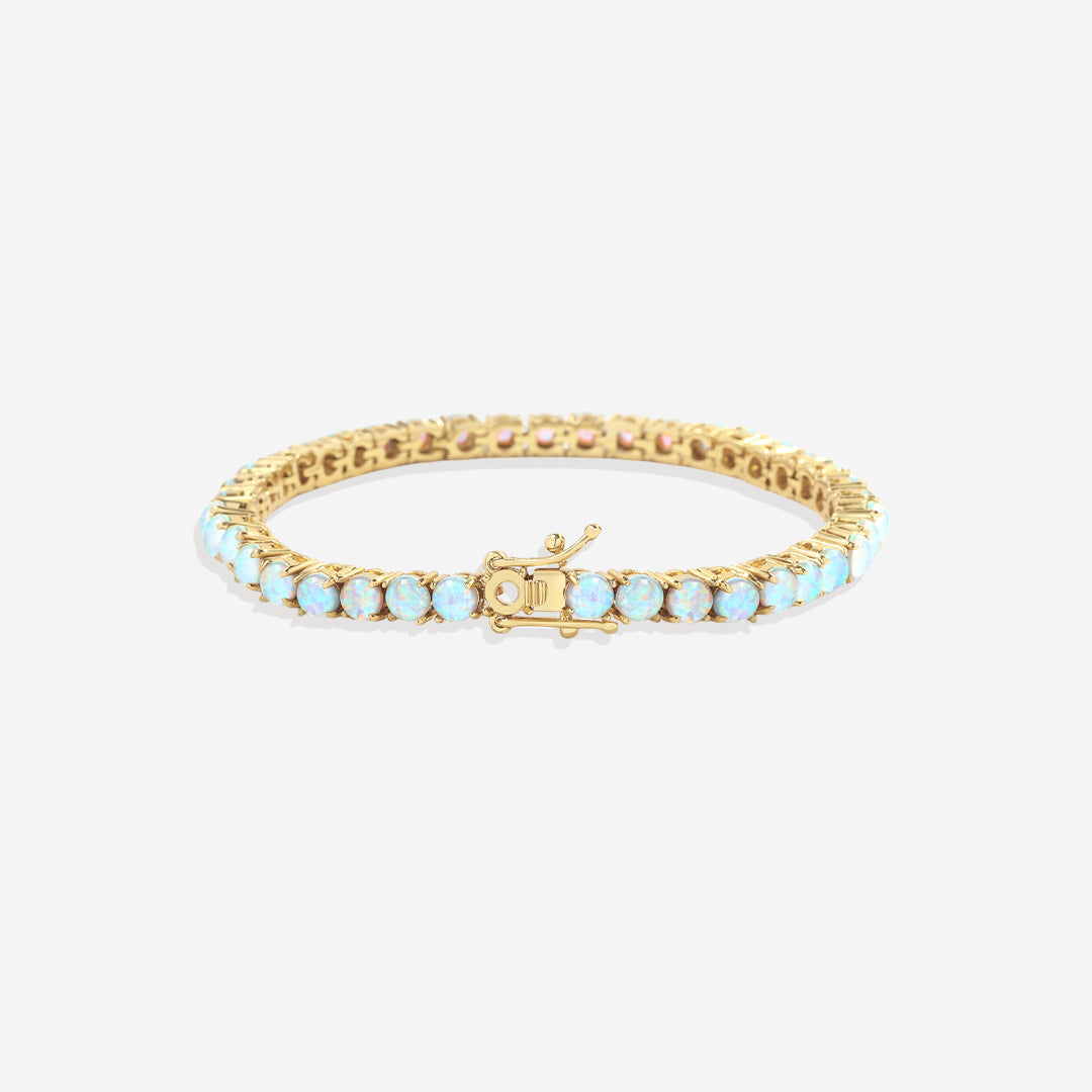 Gold bracelet with light blue stones on a white background