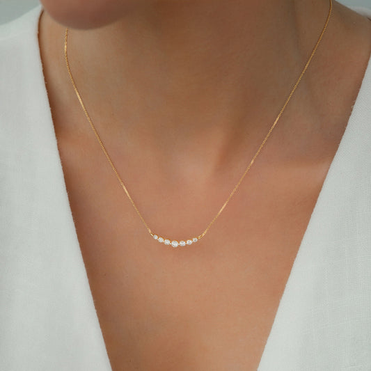 Gold necklace with small diamonds on a white background