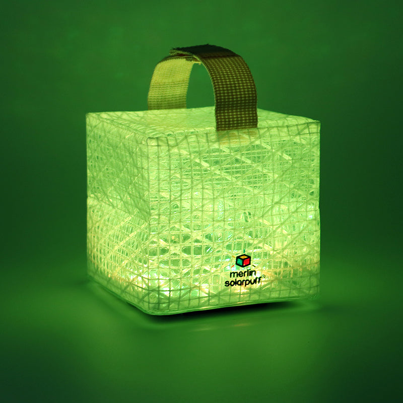 Green cube-shaped lantern with grid pattern and handle on a green background, featuring the Merlin SolarPuff logo.
