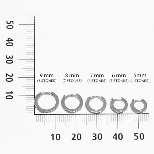 Gold hoop earrings with small diamonds on a white background