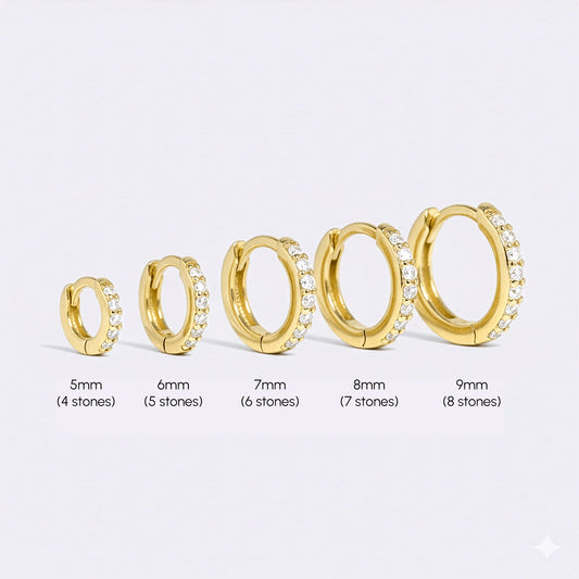 Gold hoop earrings with small diamonds on a white background