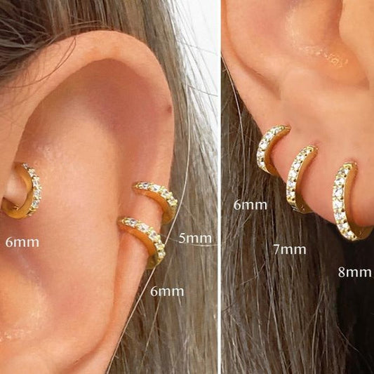 Gold hoop earrings with small diamonds on a white background