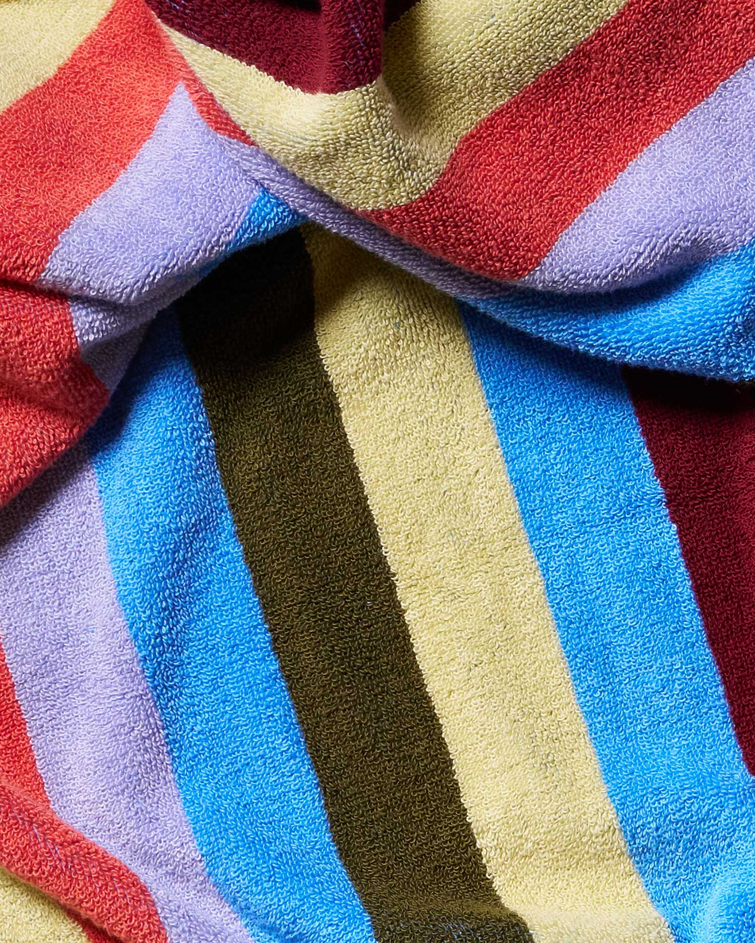 Close-up of a colorful striped fabric with red, blue, yellow, and purple stripes.