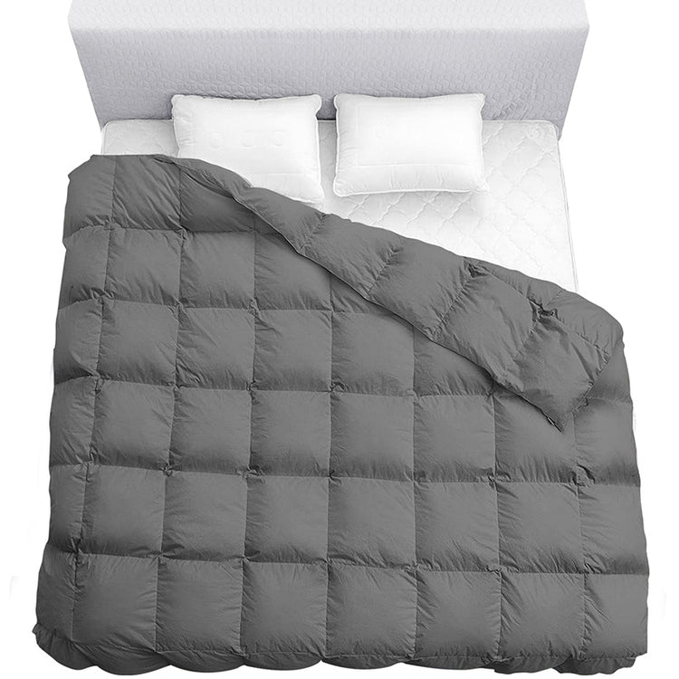 Gray quilted comforter on a bed with white pillows and headboard.