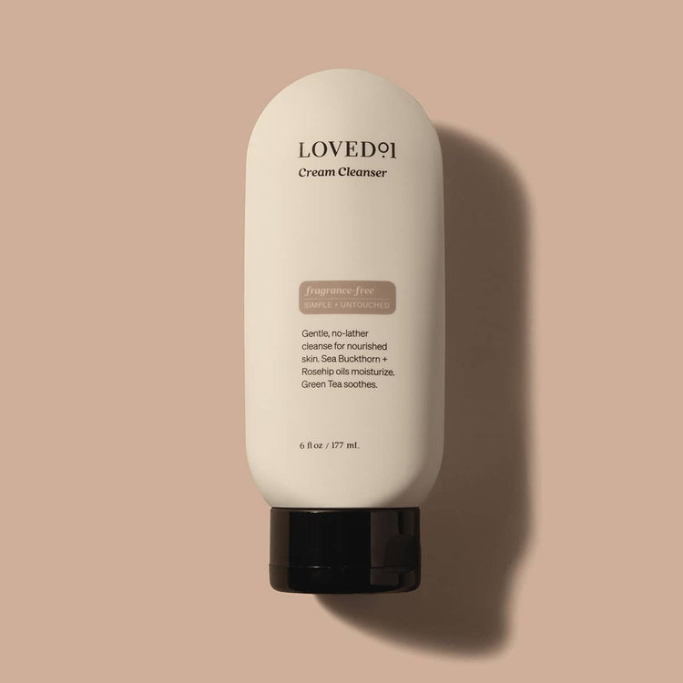 Loved9 Cream Cleanser bottle on a beige background