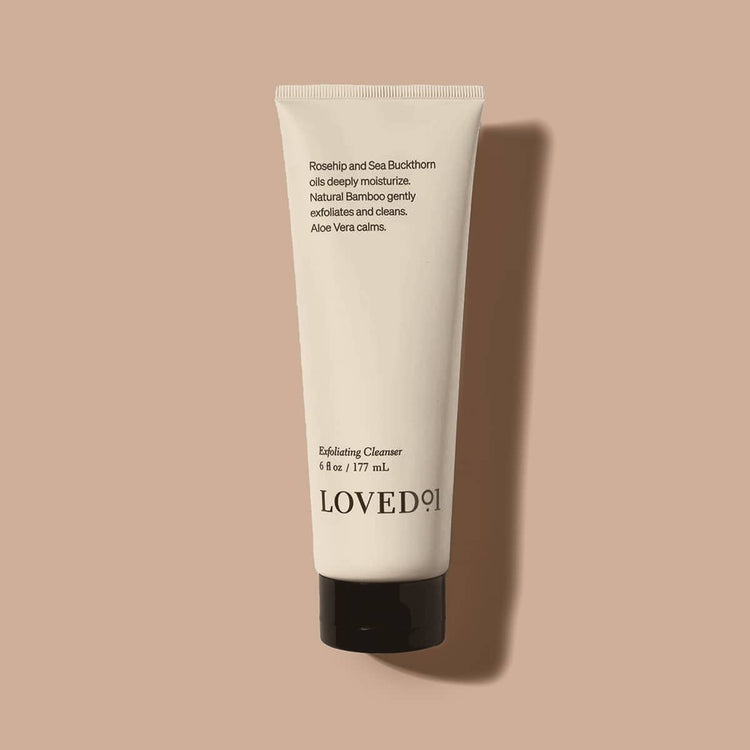 Tube of LOVED101 Exfoliating Cleanser on a beige background