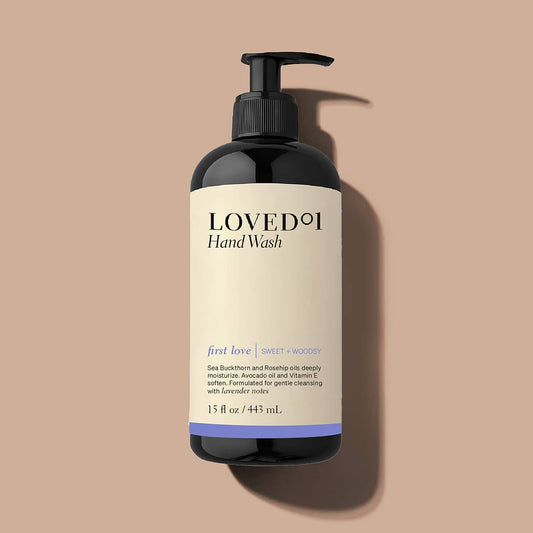 Two bottles of 'Loved' hand wash and lotion with a black pouch on a white background