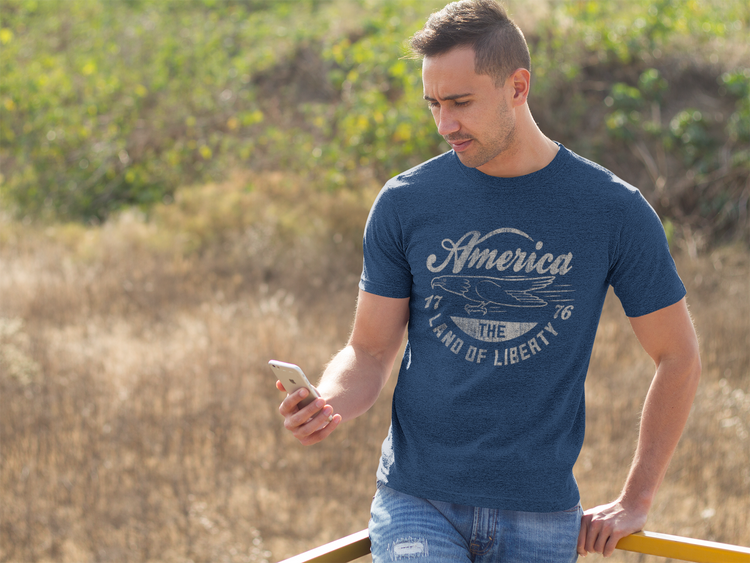Man wearing a blue t-shirt with 'America' text, standing outdoors.