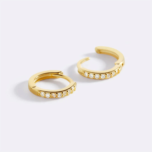 Gold hoop earrings with small diamonds on a white background