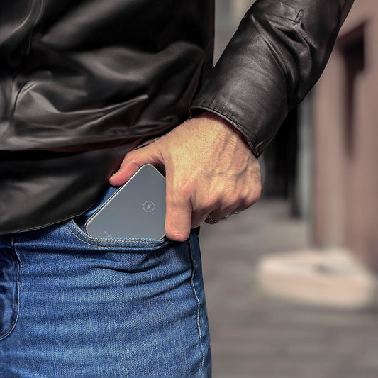 A foldable wireless charger stand with a smartphone, smartwatch, and earbuds being charged.