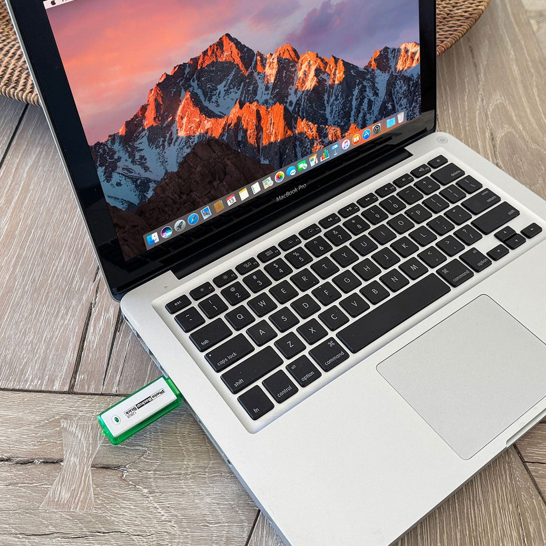 Laptop with a USB drive on a wooden surface