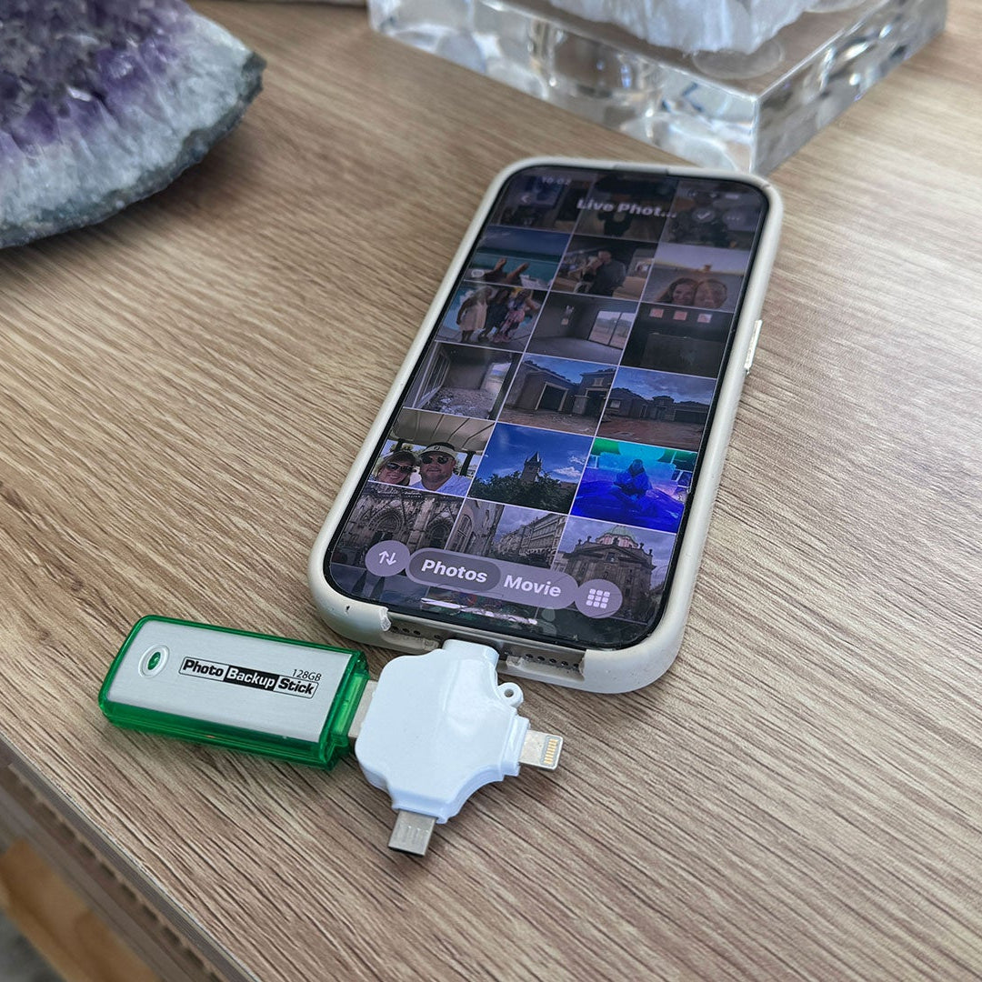 Phone with photo app open, USB drive, and crystal on wooden surface