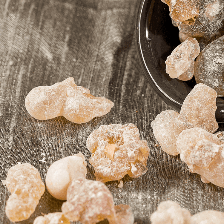 Candied fruits on a textured surface with a bowl in the background
