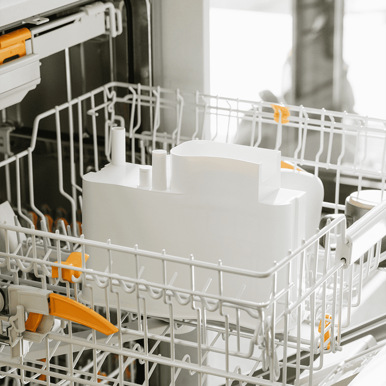 Open dishwasher with white dishes and silverware inside