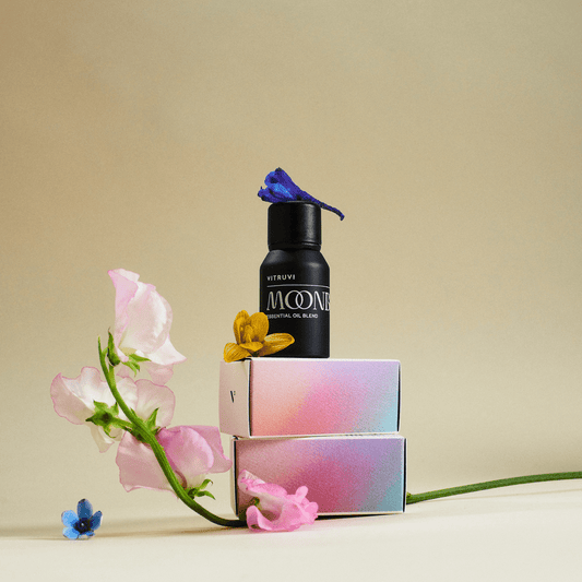 Black bottle of Vitruvi Moone essential oil blend on a transparent background