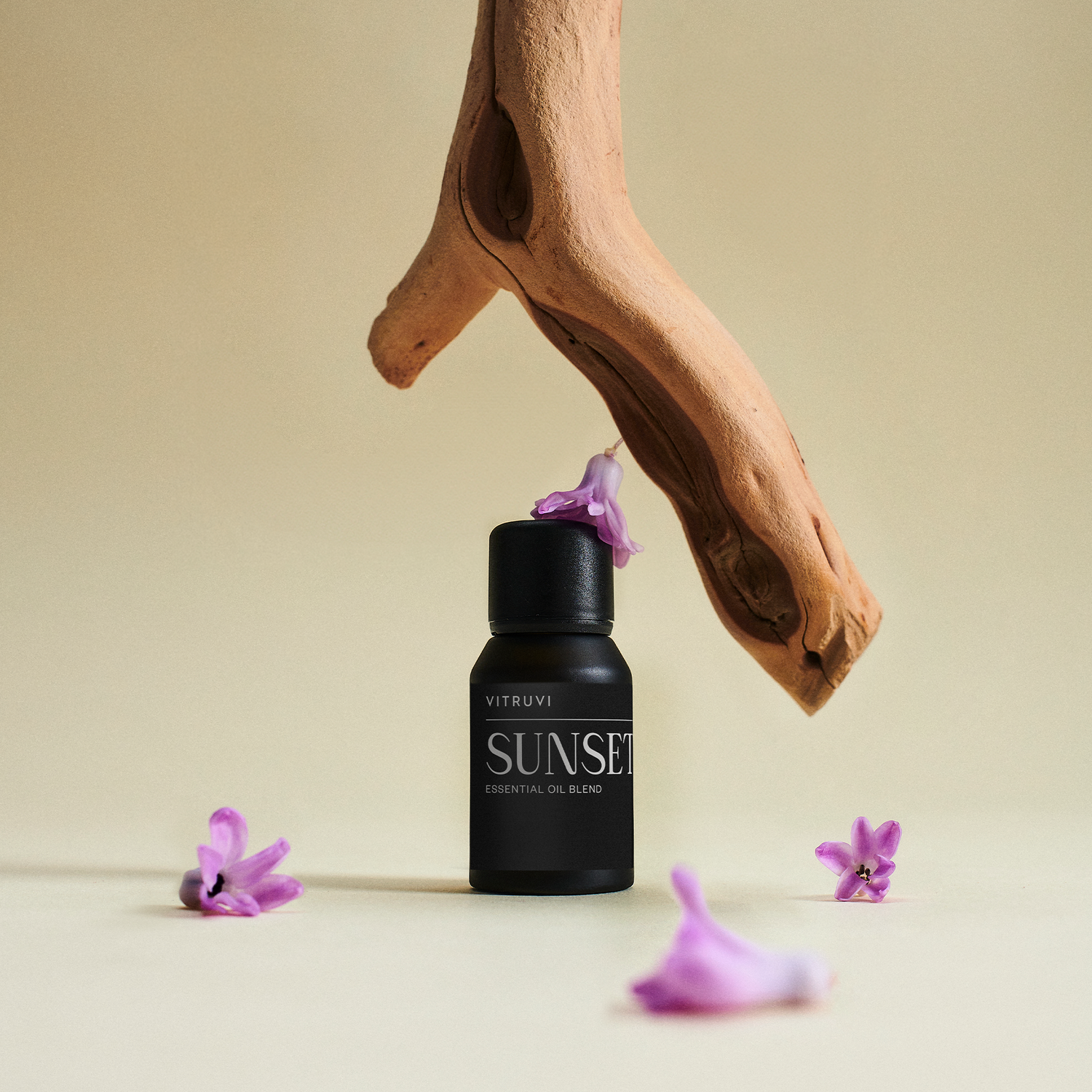 Black bottle labeled 'Sunset' with purple flowers on a beige background