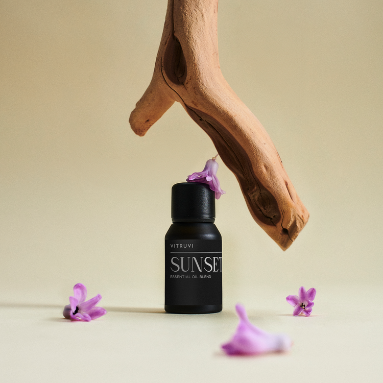 Black bottle labeled 'Sunset' with purple flowers on a beige background