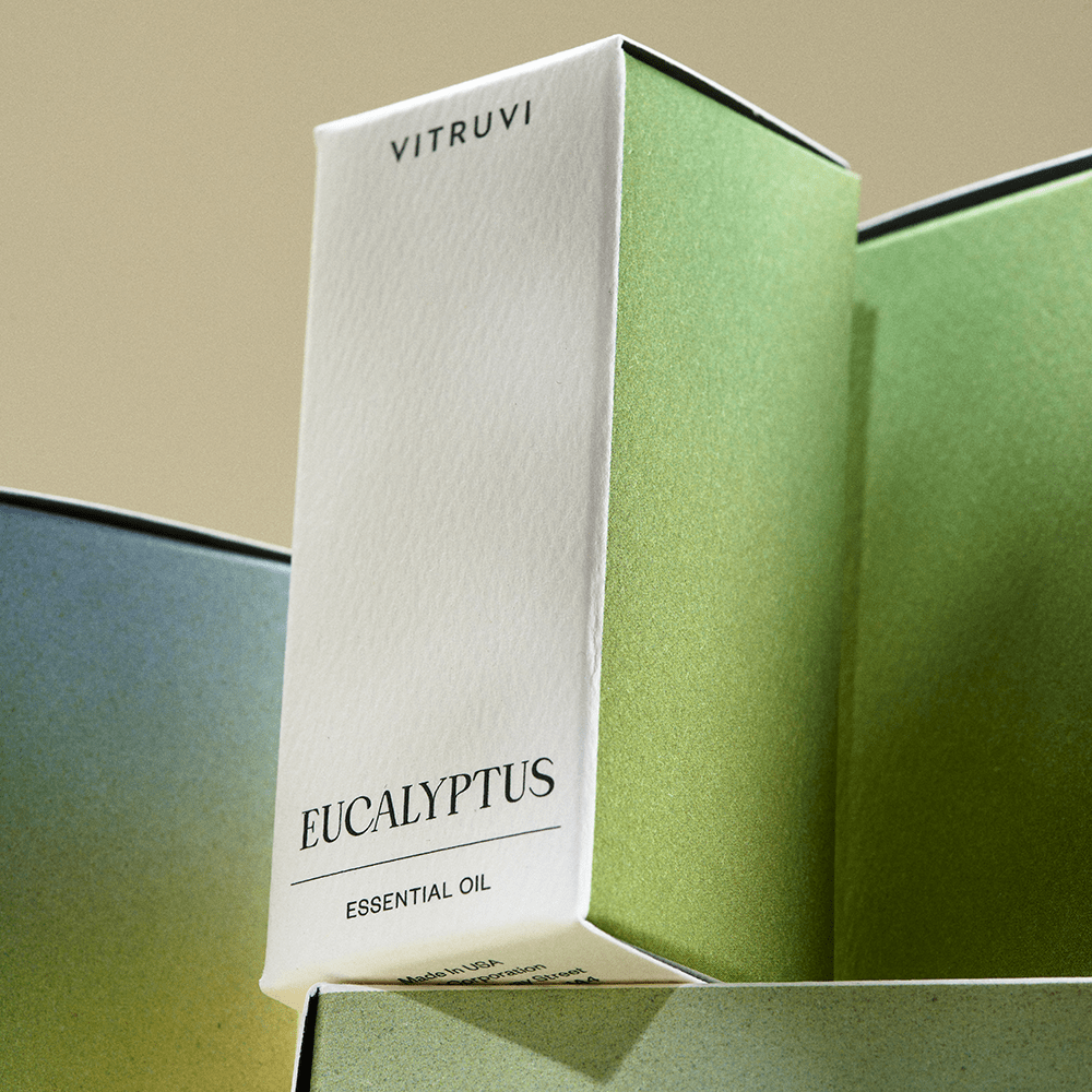 Vitruvi Eucalyptus essential oil packaging with a gradient background
