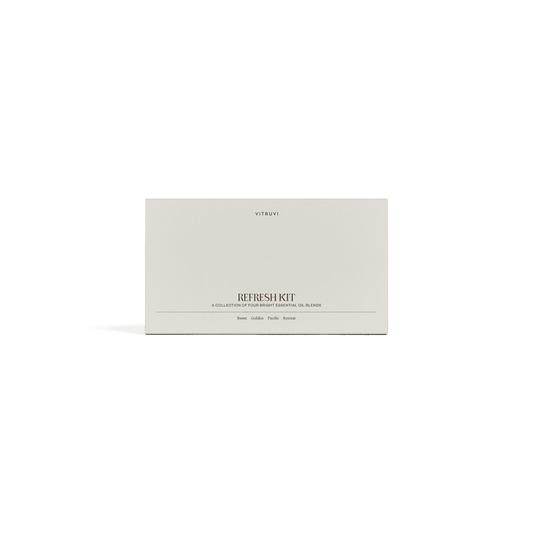 Four Vitruvi essential oil blend bottles labeled 'Boost', 'Gold', 'Pacify', and 'Retr' on a green background.